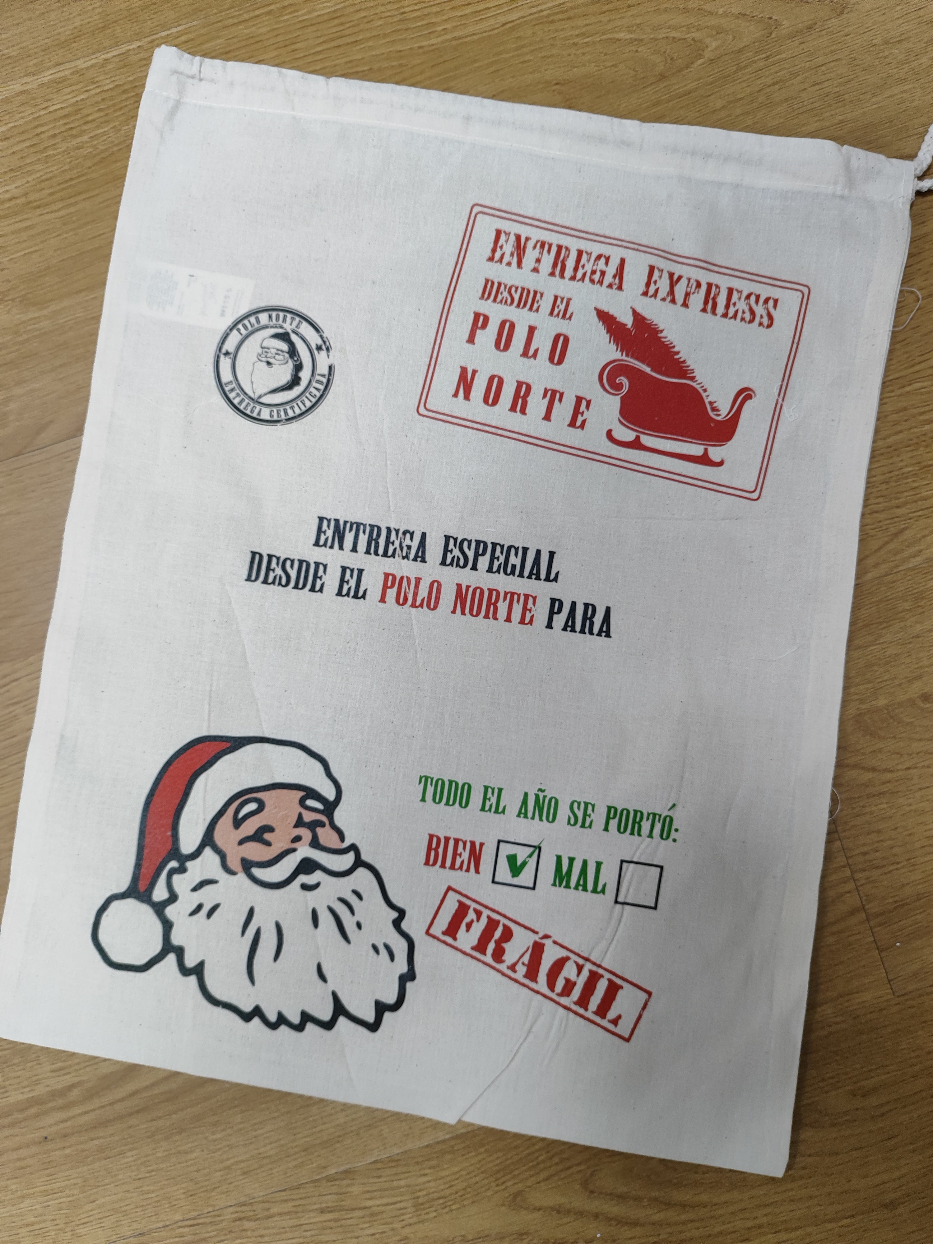 Saco Papá Noel L con pequeño defecto de impresion, arruga en las letras